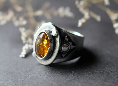 A halo in the darkness, sun ring in sterling silver and amber