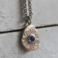 Circle of Leaves, floral mandala pendant in silver and blue sapphire