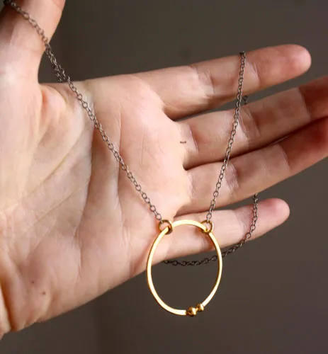 Golden enclosure, couple’s circle necklace in gold and silver