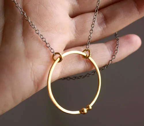 Golden enclosure, couple’s circle necklace in gold and silver