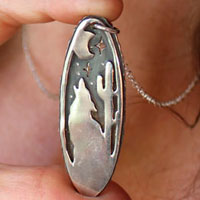 Howling at the moon, desert coyote under the moon necklace in sterling silver