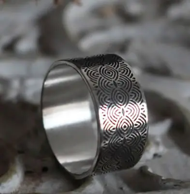 Silver ring of spirals reminiscent of the engraved stones of the Neolithic period