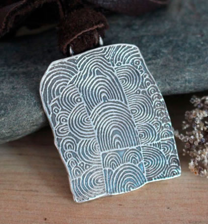 Gavrinis Cairn Necklace showing the Neolithic motifs of one of the stones in the dolmen corridor